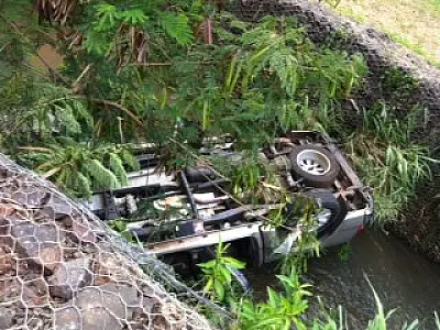 Curva faz motorista perder o controle e capotar caminhonete e cair em córrego
