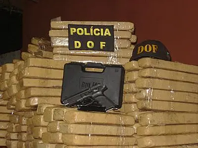 DOF apreende 337kg de maconha e duas pistolas em carreta