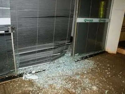 Carro bate em poste, sua roda escapa e quebra porta de vidro de agência em Dourados
